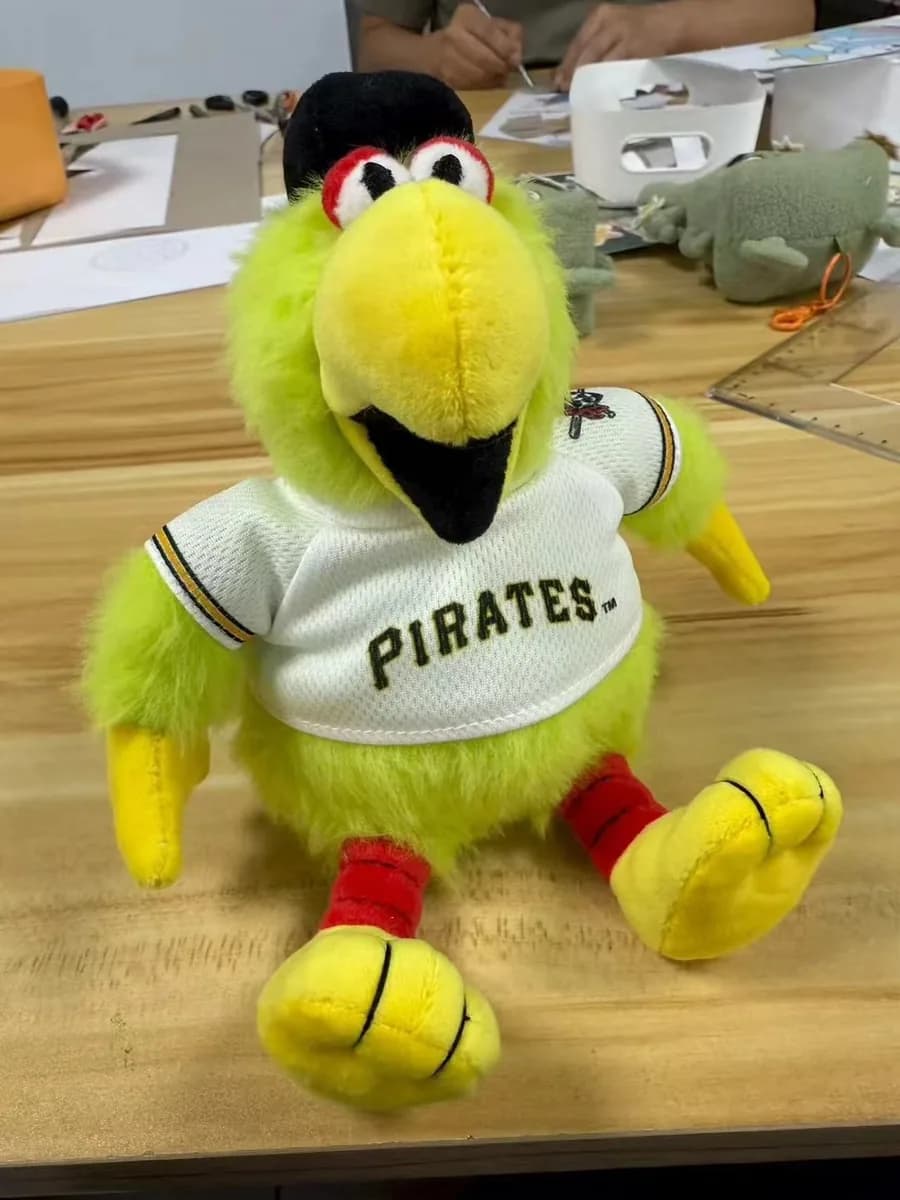 Parrot mascot plush in a baseball uniform with embroidered lettering